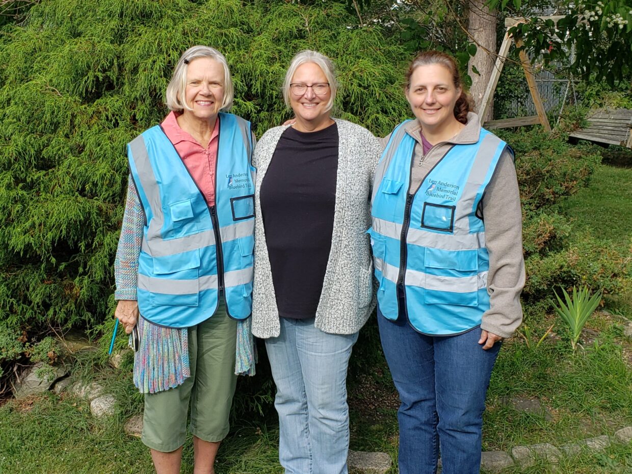 three women posing for picture in yard